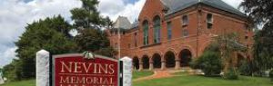 Nevins Library sign in foreground and Nevins Memorial Library Building in background