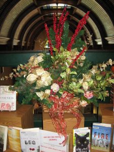 A bouquet of Christmas flowers above a bunch of books