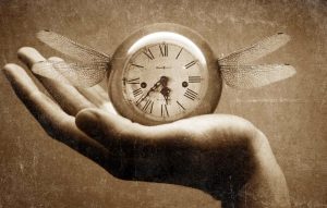 A hand holding a clock.