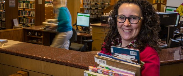 A picture of a lady holding books.