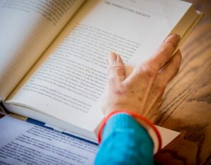 A picture of a book and hands.