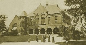Old picture of the Nevins Library with women milling around outside in long dresses