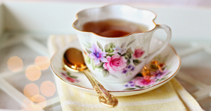 Teacup filled with tea and spoon next to it