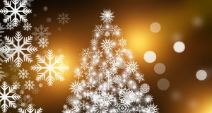 White Christmas Tree shape made out of different snowflake patterns on a hazy yellow/gold background