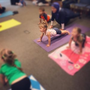 Young Girl doing Yoga on a purple yoga mat