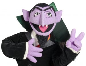 The Count from Sesame Street smiling and holding up two fingers