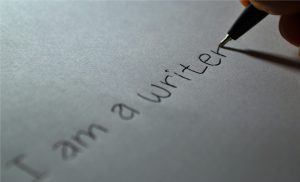 A pen writing "I am a writer" on a piece of paper