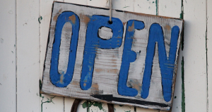 Blue and White Open sign on side of barn