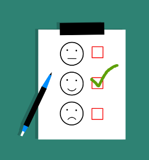 Three smiley faces on a piece of paper with checkboxes next to them and a checkmark in the middle smiling one