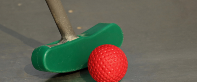 green putter next to an orange mini golf ball