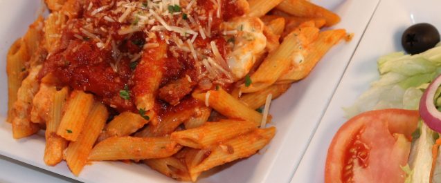 Red sauce on top of pasta in a pile
