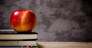 Apple sitting on pile of books