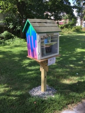 Little Free Library with side painted as dripping paint in green, blue, purple, and pink