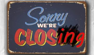 Blue worn looking sign with the text Sorry We're Closing on it