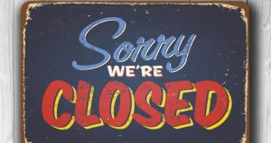 Blue worn out looking sign that says Sorry We're Closed. With the word closed in red letters with a yellow drop shadow