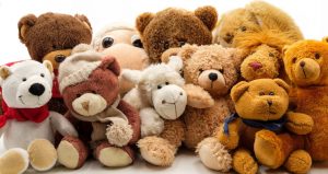 A bunch of different stuffed animals smushed all together and sitting like they were taking a portrait together