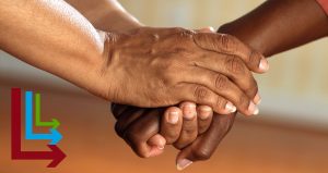 Two older dark skinned hands holding each other. With the Live Long and Learn Symbol in the lower left hand corner overlayed