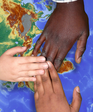 Three hands touching over a map