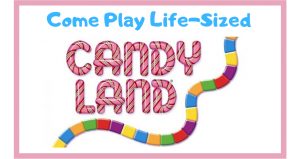 Candyland game multicolored road with the Candy Land logo above it and the words Come Play Life-Sized above the logo