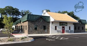 Irish Cottage building, partially made of brick, partially of white stucco with empty parking space in front of it