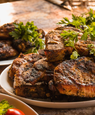 A plate of well done meat, possibly steak, with a garnish on the top