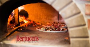 A pizza in a brick oven with the logo of Bertucci's Brick Oven Pizza and Pasta at the bottom