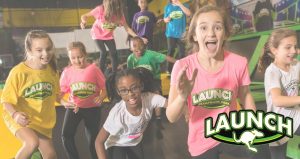 Kids in Launch Trampoline Park shirts of many colors jumping up and down and smiling with the Launch Logo in the bottom right corner