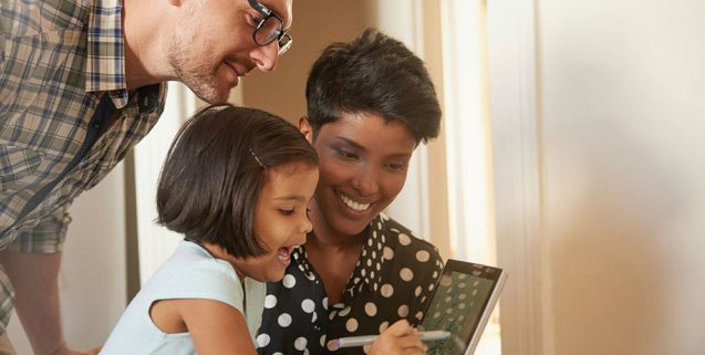 A dark skinned woman and light skinned man both watching as a young girl uses a tablet