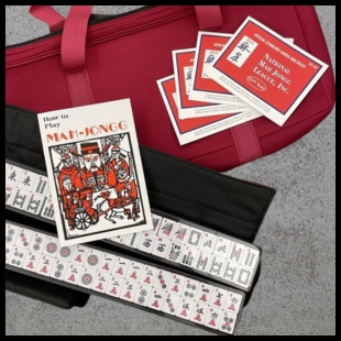 Mahjongg Set and red carrying bag on a stone background