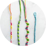 Four multicolored friendship bracelets laid out on a table