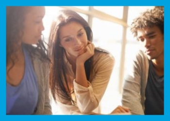 Three Teens studying something together in front of them