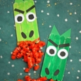 Two green frowning popsicle dragons with red 'fire' from their mouths