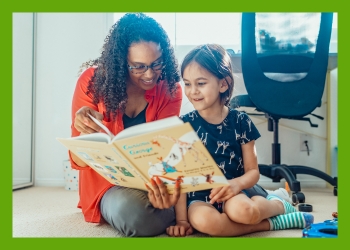 Young girl and adult woman reading Curious George book on carpeted floor