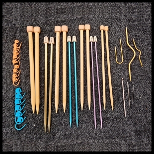 Line of wooden knitting needles sitting on grey carpet