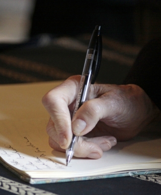 Light skinned hand writing in notebook