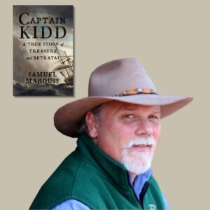 Light skinned man with a white goatee and tan cowboy hat with the book cover of Captain Kidd by Samuel Marquis set off to the upper left