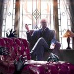 Man sitting in a chair in front of a window with a lamp next to him, and black latex looking hands crawling all over a sofa in front of him