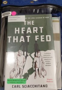 Blue kit bag with the book The Heart that Fed by Car Sciacchitano showing