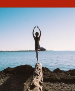 Woman standing on the edge of a rock in a yoga pose
