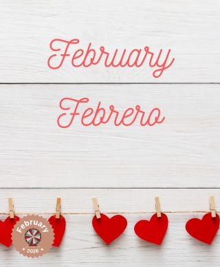 An off white wall with the words February and Febrero on it and cut out hearts put up with clothespins in a row under the words