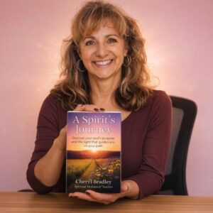 Light skinned brunette woman smiling and holding book