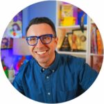 Jarrett Krosoczka circle315 Smiling light skinned man in blue collared shirt with blue glasses