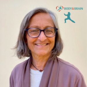 Smiling light skinned woman with gray hair and glasses